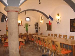 EmskirchenAlte Poststation Goldener Hirsch的一间带桌椅和旗帜的用餐室