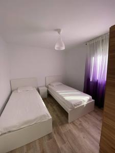 萨瓦德尔Josep Tarradellas Entire Apartment的一间卧室设有两张床和紫色窗帘