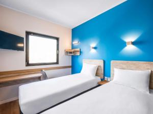 圣地亚哥ibis budget Santiago Providencia的蓝色墙壁客房的两张床