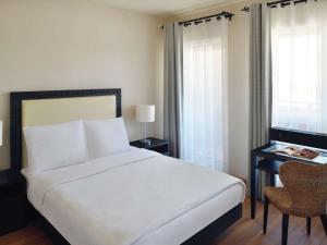亚喀巴亚喀巴莫温匹克度假公寓的卧室配有白色的床和带窗户的书桌