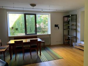 雷根斯堡F80-Die FEINE Ferienwohnung的客房设有桌椅和窗户。