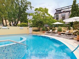 宾茨库翰斯宾斯查尔梅旅游酒店的一座带椅子的游泳池以及一座建筑