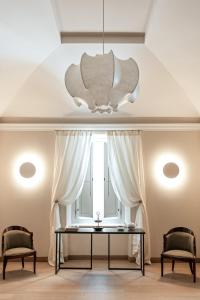 拉奎拉Dimora Fortebraccio的一间带桌子和两把椅子的用餐室以及窗户。