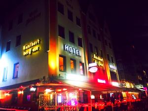 科隆库尼博得菲丝高级酒店的夜间在大楼内有 ⁇ 虹灯标志的酒店