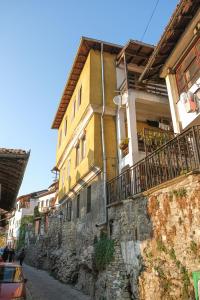 大特尔诺沃The Sunny Guest House of Veliko Tarnovo-Amazing View, Top Location的街道旁石墙上的黄色房子