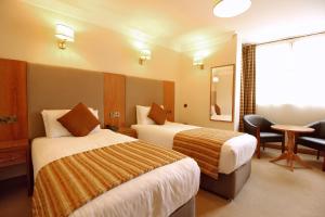 都柏林城堡酒店的酒店客房设有两张床和一张桌子。