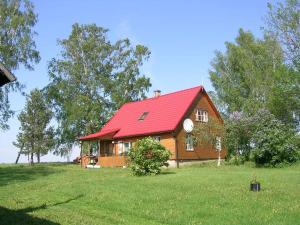 Tõlliste卡尔达塔鲁度假屋的绿色田野上一座红色屋顶的房子