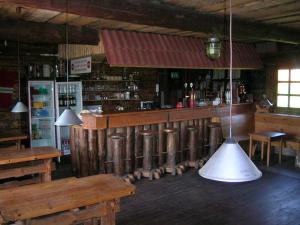 Tõlliste卡尔达塔鲁度假屋的餐厅设有酒吧,天花板上挂着灯