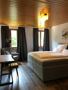 耶斯特滕Stadtvilla mit Pool的一间卧室配有一张床、一把椅子和窗户。