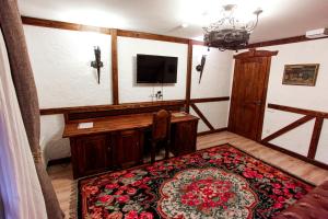 TrebujeniVila Etnica的一间配备有书桌、电视和地毯的客房