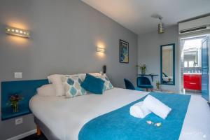 拉罗谢尔Un Hotel sur le Port的卧室配有一张蓝色色调的大型白色床。