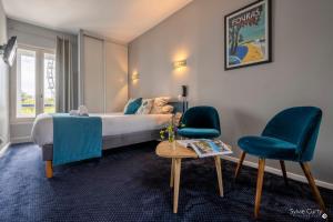 拉罗谢尔Un Hotel sur le Port的一间卧室配有一张床、两把椅子和一张桌子