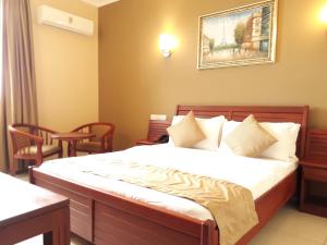达累斯萨拉姆切尔西酒店的卧室配有一张床和一张桌子及椅子