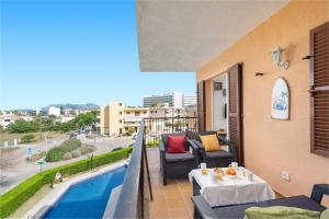 波连斯萨Tamarels beach apartment in Pollensa的阳台配有沙发、桌子和游泳池。