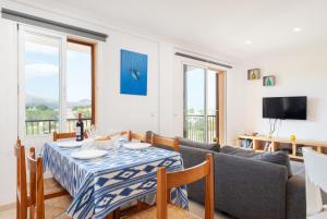 波连斯萨Tamarels beach apartment in Pollensa的客厅配有桌子和沙发