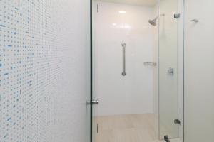 瓜达拉哈拉瓜达拉哈拉依特苏快捷假日酒店的浴室里设有玻璃门淋浴