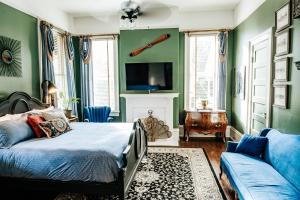 欧佩莱卡Heritage House Bed & Breakfast - Boutique Adults-Only Inn的一间卧室设有绿色的墙壁、一张床和一张沙发