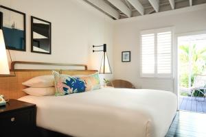 基韦斯特Ella's Cottages - Key West Historic Inns的一间白色卧室,配有床和庭院