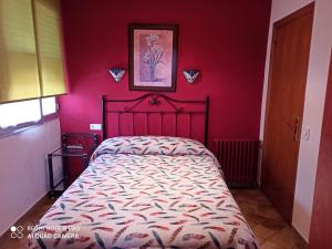 FaberoPENSION LA PARADA的一间卧室配有一张红色墙壁的床
