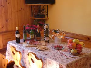卡斯泰洛泰西诺Baita Figliezzi的一张桌子,上面放有瓶装葡萄酒和水果