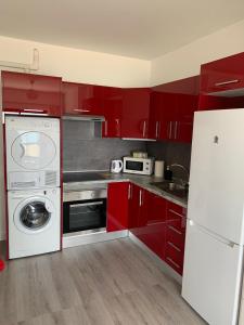 大塔拉哈尔Apartamentos Candelarita的一间带红色橱柜和洗衣机的厨房