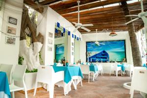 坎昆Grand Oasis Palm - All inclusive的一间设有蓝色桌子和白色椅子的餐厅