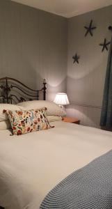 利斯坎诺Bay View House的卧室配有带枕头和灯的白色床