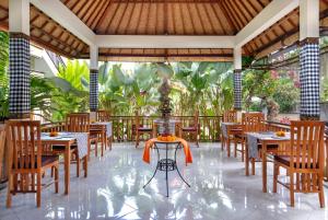 乌布Hidden Padma Retreat的一间带桌椅的餐厅和一个喷泉