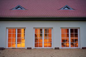 FischbachUnterpetersbächlerhof的白色的房子,有三扇窗户和红色屋顶