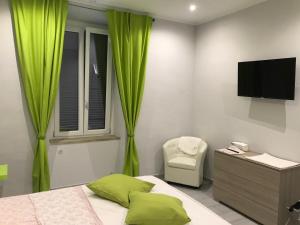 卡塞勒托瑞尼斯Rosa verde的一间卧室配有一张带绿色窗帘的床和电视。