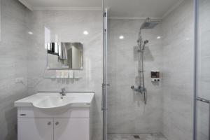 马公凯乐漫游民宿的浴室配有白色水槽和淋浴。