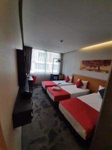 伊斯坦布尔萨普库机场酒店的酒店客房设有三张床和电视。