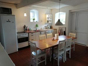 JelsPension Slotsgaarden jels的厨房配有木桌和白色家电