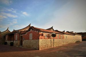 金宁乡金門古寧歇心苑官宅古厝民宿 Guning Xiexinyuan Historical Inn的前面有栅栏的建筑