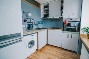 瓦尔米耶拉City center Appartment的厨房配有白色橱柜、洗衣机和烘干机