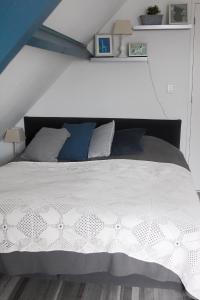 PurmerBed en Breakfast Het Friesche Paard的一间卧室配有白色床和蓝色枕头