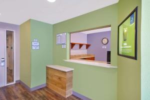 圣查尔斯WoodSpring Suites St Louis St Charles的一间设有绿色墙壁、柜台和镜子的客房