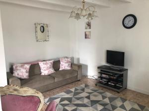 Oradour-FanaisGîte des Roses的带沙发和电视的客厅