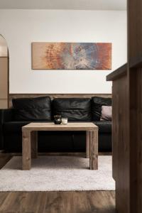 索尔登Apart Life的客厅配有一张咖啡桌和一张黑色沙发