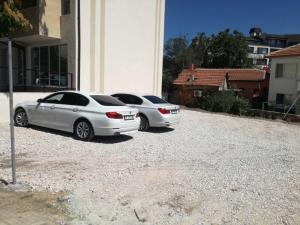 扬博尔family hotel - City hotel yambol的两辆白色汽车停在大楼旁边