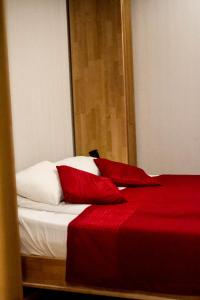 尤尔马拉日落酒店的一张带红色床单和白色枕头的床