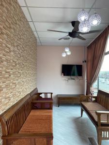 CukaiIlham Bonda 2 Homestay的客厅设有长椅、电视和墙壁