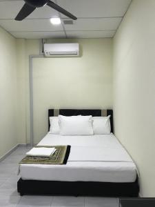 CukaiIlham Bonda 2 Homestay的一张带白色床单和枕头的床