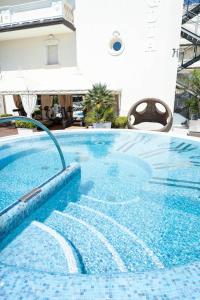 切尔维亚Hotel Conchiglia的蓝色瓷砖地板的酒店游泳池