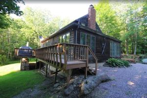 斯托Quaint Stowe Cabin的小屋设有大甲板和烧烤架