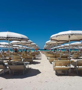 托雷圣乔万尼乌萨兰托米尔弗朗酒店的海滩上的一排椅子和遮阳伞