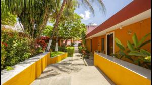 科苏梅尔Hotel Caribe的棕榈树建筑旁的黄色围栏