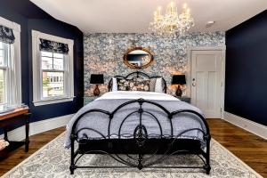 夏洛特顿Slaymaker & Nichols Gastro House & Inn的一间卧室配有一张带蓝色墙壁和吊灯的床。