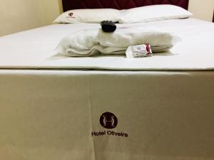 伊帕廷加Hotel Oliveira - By UP Hotel的一张床垫,上面有酒店马哈标志