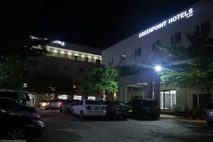 拉各斯GreenPoint Hotel的晚上在酒店前面的一个停车场